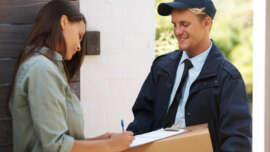 Male courier delivering a parcel to a woman at her front door